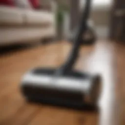 A sleek canister vacuum on a hardwood floor with pet hair